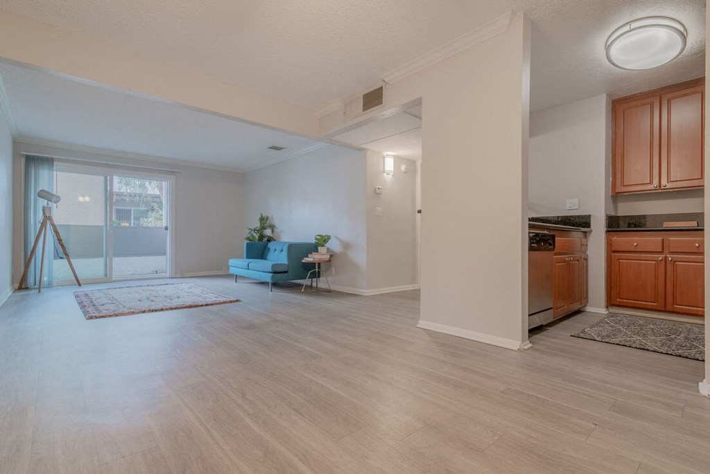 an open living room with a kitchen and a door to a balcony at City View Apartments at Warner Center, Woodland Hills