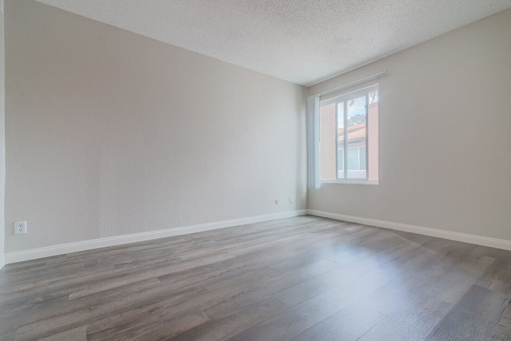 an empty living room with wood floors and a window at City View Apartments at Warner Center, California