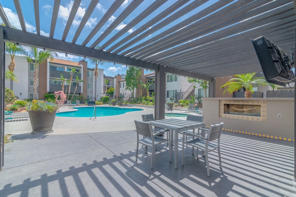 a patio with a table and chairs next to a pool at City View Apartments at Warner Center, California