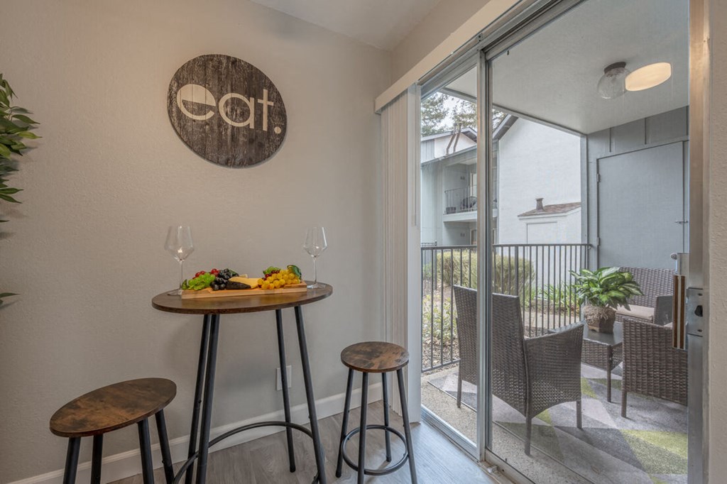 a small table with two stools in a room with a sliding glass door at Danville Park, Danville, CA