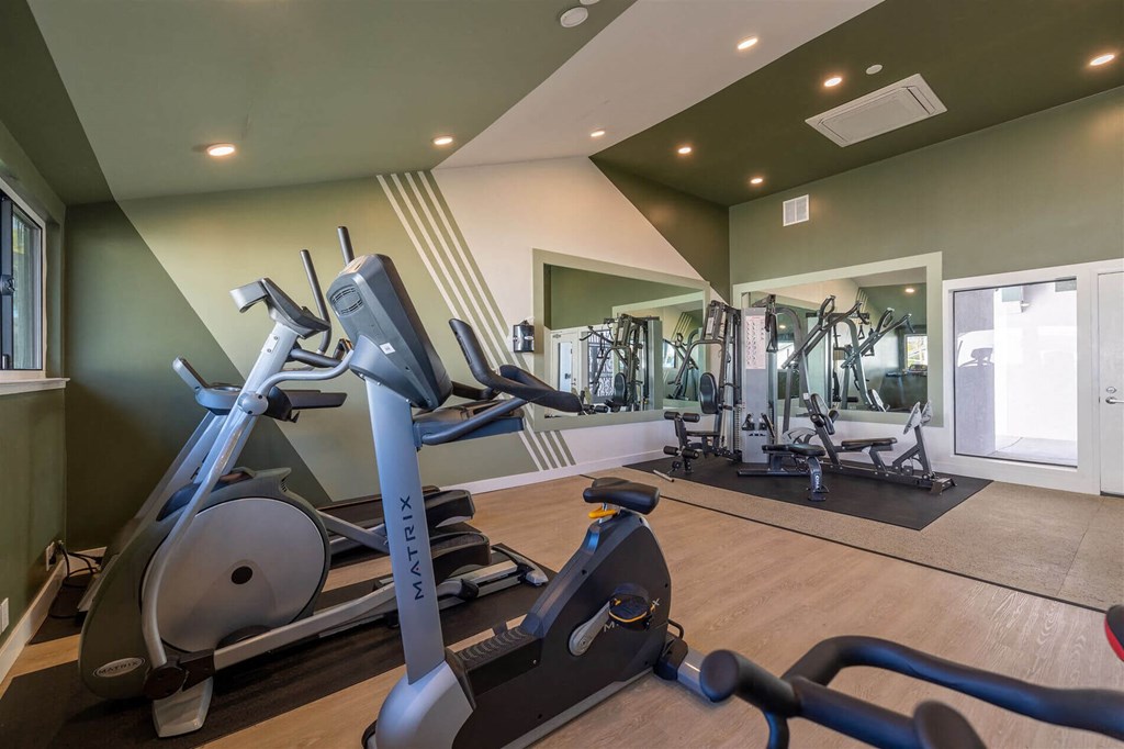 a gym with cardio equipment and weights on a wooden floor at Diablo Vista, California, 94551