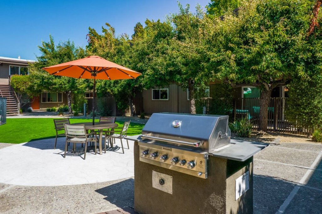 a gas grill on a patio with a table and umbrella at Element LLC, Sunnyvale, 94086