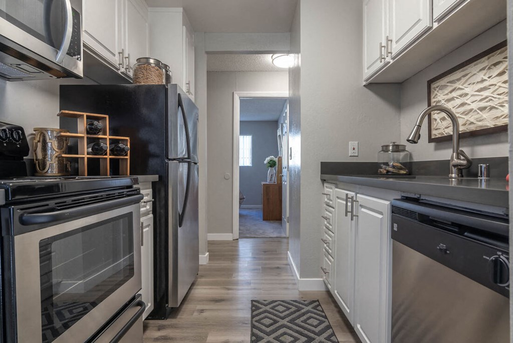 Kitchen with black appliances and white cabinets at Sunnyvale Crossings Apartments, Sunnyvale