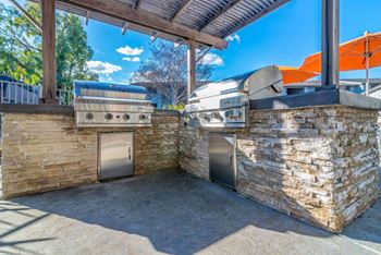 the outdoor kitchen has a grill and two bbqs at Sunnyvale Crossings Apartments, LLC, Sunnyvale