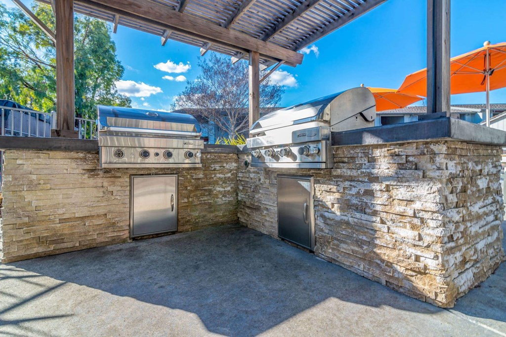 Outdoor kitchen with a grill and two bbqs at Sunnyvale Crossings Apartments, Sunnyvale, CA, 94087