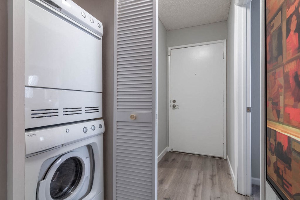 Washer and dryer in a laundry room with a door at Sunnyvale Crossings Apartments, Sunnyvale, CA, California, 94087