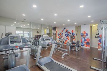 a gym with cardio equipment and mirrors in a building at Sunnyvale Crossings Apartments, LLC, Sunnyvale, CA 94087