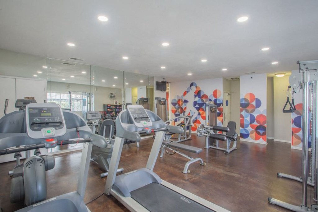 a gym with cardio equipment and mirrors in a building a gym with cardio equipment and mirrors in a building at Sunnyvale Crossings Apartments, LLC, California, 94087
