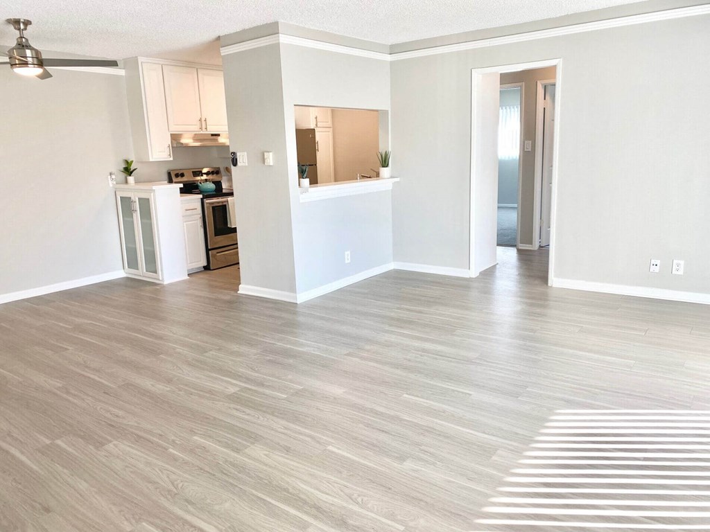an empty living room and kitchen with a wood floor at The Flats on Addison, Sherman Oaks, 91423