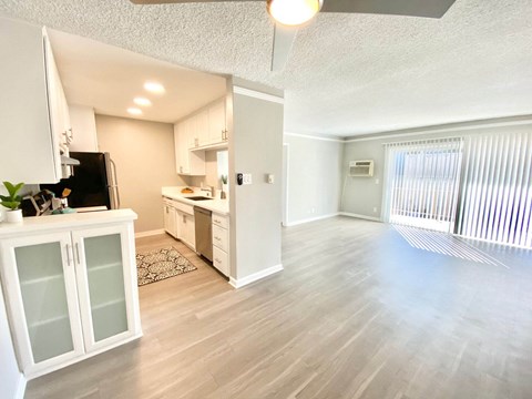 an empty living room and kitchen with a sliding glass door