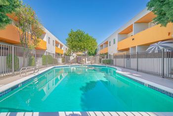 a swimming pool in front of an apartment building with a pool at The Flats on Addison, Sherman Oaks, CA 91423