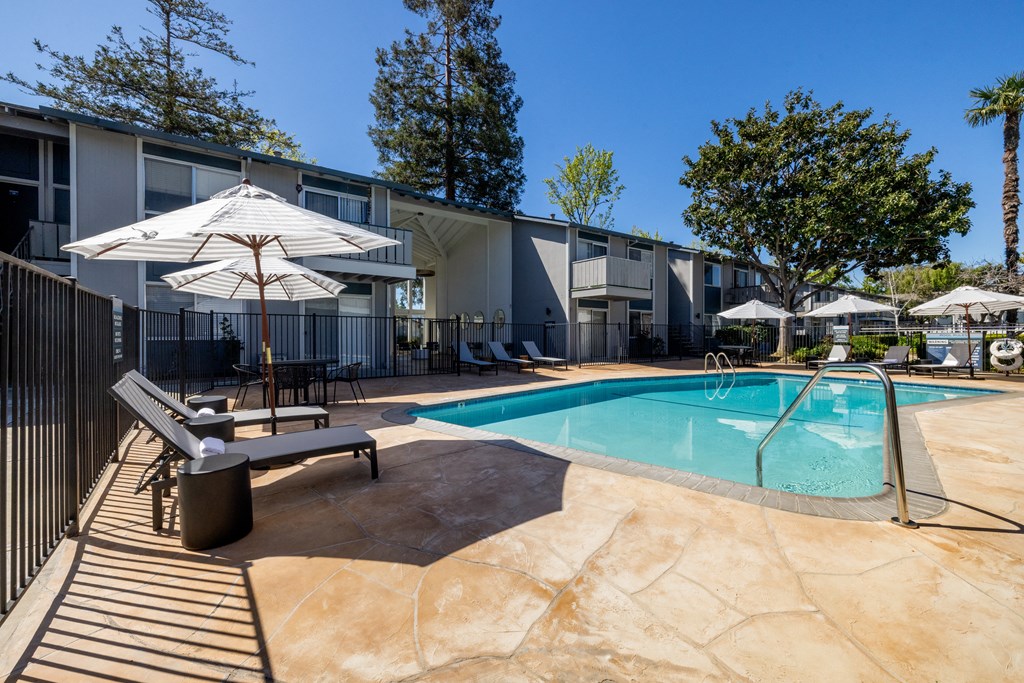 our apartments have a swimming pool and a patio with chairs and umbrellas at Campbell West Apartments, Campbell, 95008