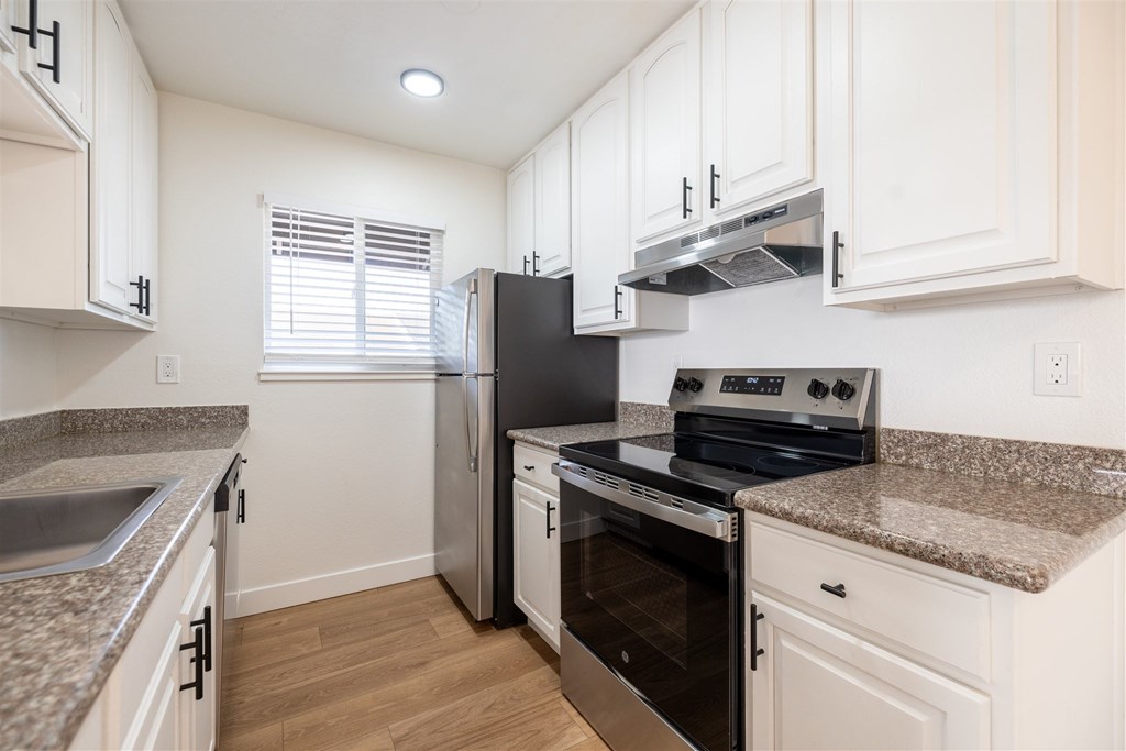 A kitchen with a black refrigerator, stove, and oven.at Summerhill Place Apartments, Union City California