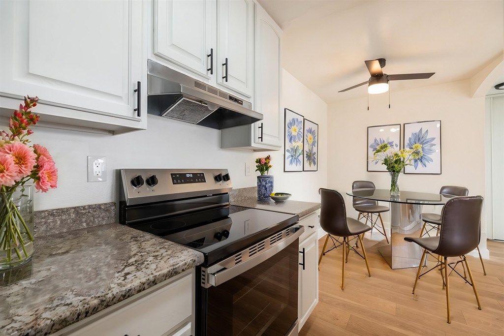 A kitchen with a black stove top oven and a marble counter top.at Summerhill Place Apartments, Union City, CA 94587