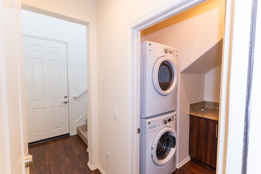 a washer and dryer in a laundry room with a white door at The Vines at Riverpark, LLC, California, 93036