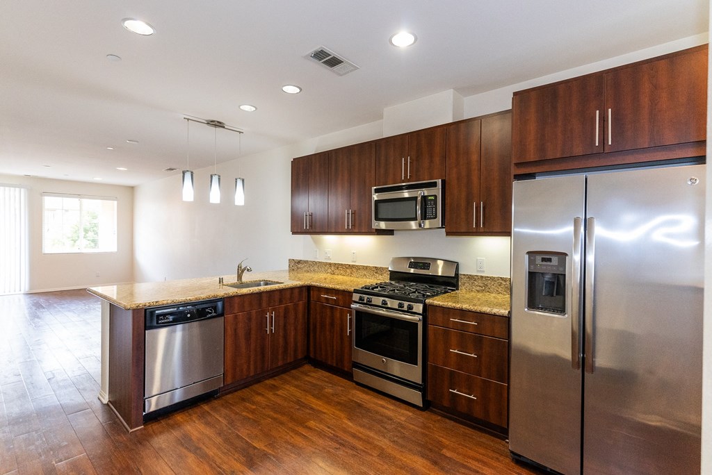 a kitchen with stainless steel appliances and wooden cabinets at The Vines at Riverpark, LLC, California, 93036