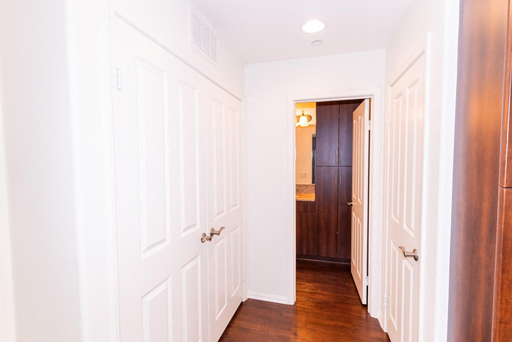 the hallway of a home with white walls and wood floors at The Vines at Riverpark, LLC, California, 93036