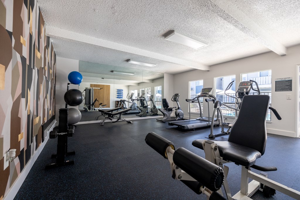 a gym with weights and other exercise equipments in a room with a large window at Campbell West Apartments, California 95008