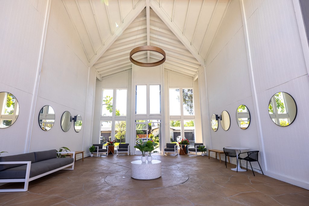 a living room with a vaulted ceiling and large windows at Campbell West Apartments, Campbell