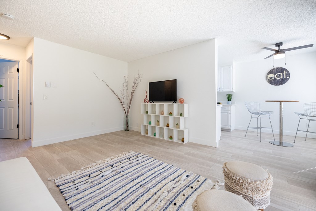 a living room with a tv and a dining room with chairs and a rug at Campbell West Apartments, Campbell, CA 95008