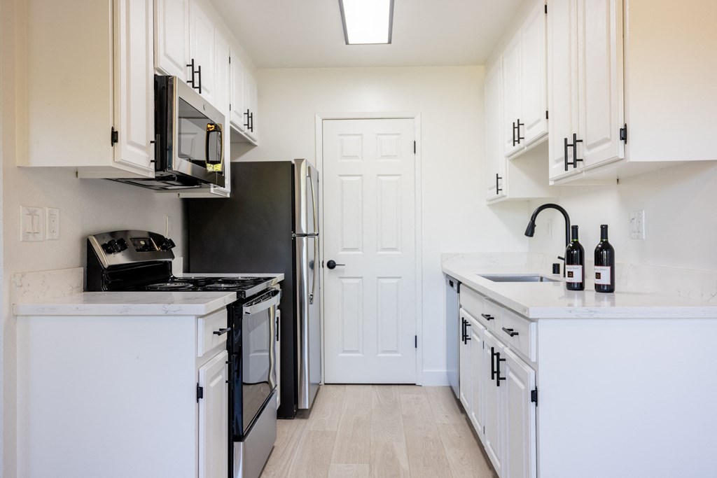 a kitchen with white cabinets and a black stove and refrigerator at Campbell West Apartments, Campbell, 95008