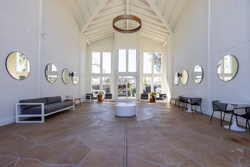 the lobby of a building with tall ceilings and large windows at Campbell West Apartments, Campbell