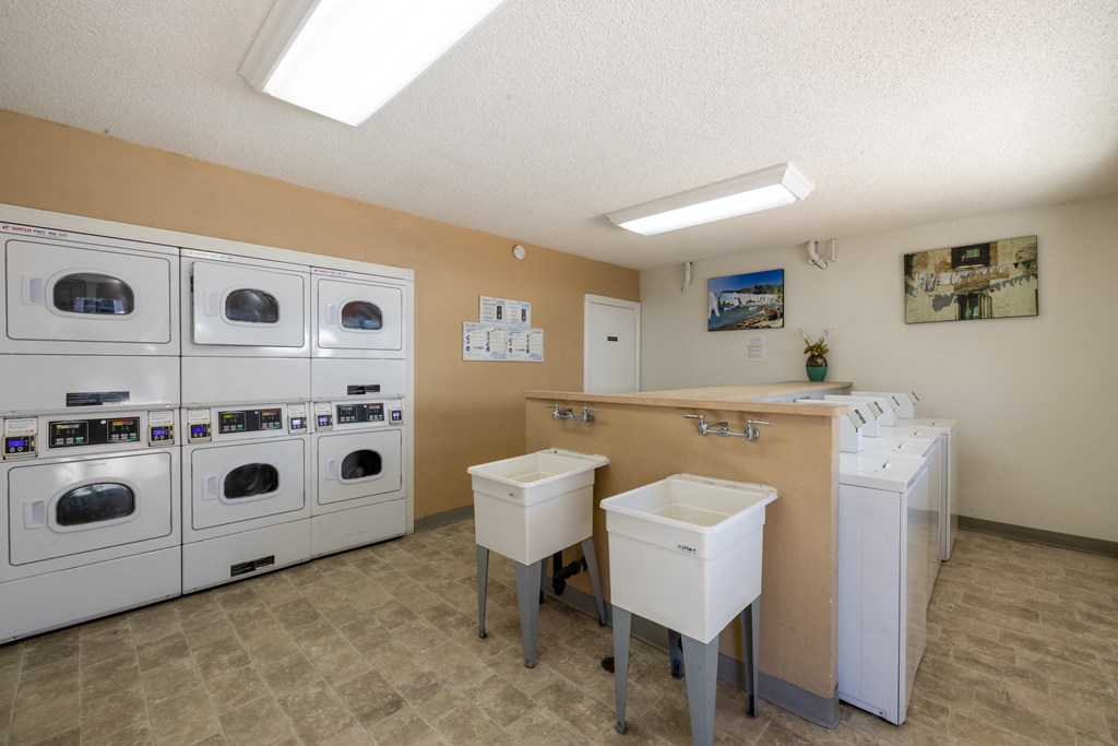 a laundry room with washers and dryers and a counter with sinks at Campbell West Apartments, Campbell, CA