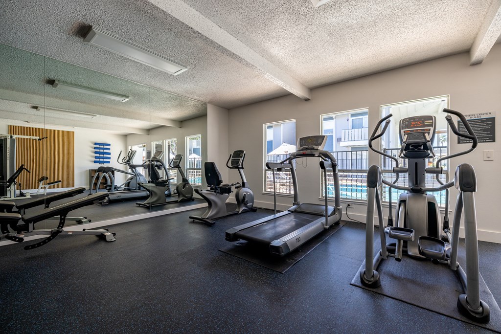 a gym with cardio machines and weights on the floor at Campbell West Apartments, California
