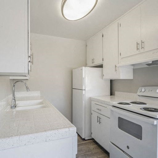 a kitchen with a stove and a sink and a refrigerator at The Arches Apartments, El Cajon California