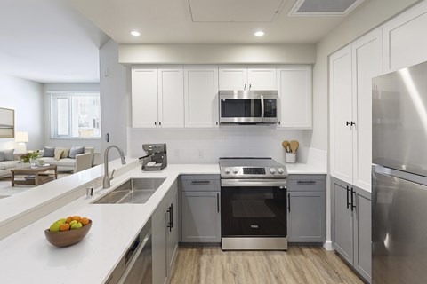 A modern kitchen with stainless steel appliances and white cabinetry.at 888 Fourth Street Apartments, LLC, Santa Rosa