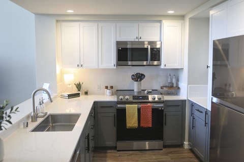 A modern kitchen with a stainless steel oven and white cabinets.at 888 Fourth Street Apartments, LLC, Santa Rosa, CA 95404