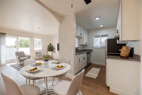 A modern kitchen with a dining table set for four.