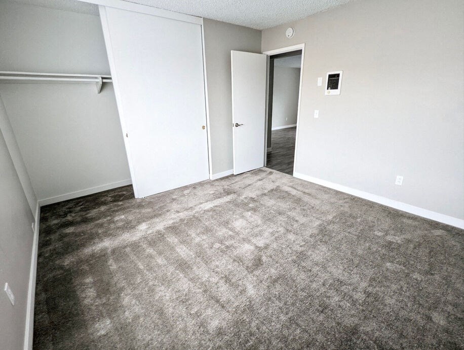 an empty living room with carpet and white wallsat The Arches Apartments, LLC, El Cajon, 92021