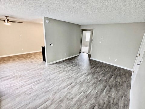 an empty living room with a hard wood floor