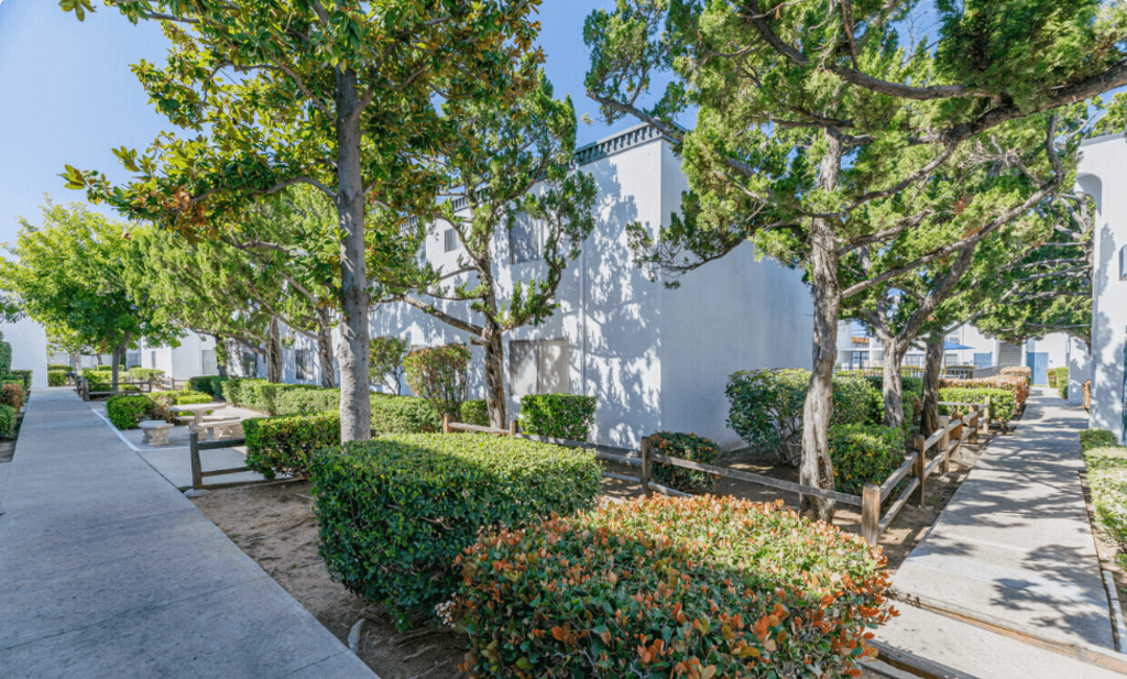 a park with trees and benches in front of a buildingat The Arches Apartments, LLC, El Cajon