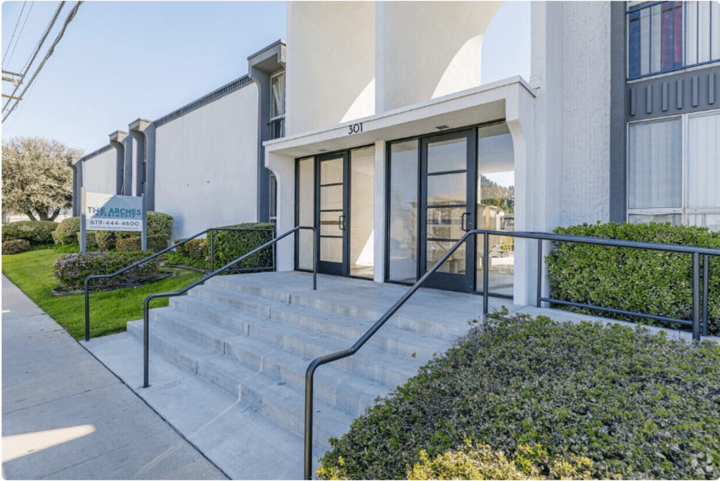 the front entrance of a building with stairs and glass doorsat The Arches Apartments, LLC, El Cajon, CA 92021