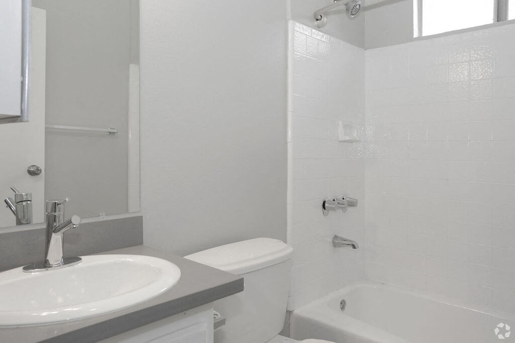 a white bathroom with a sink and a toilet  at The Marq Apartments LLC, Los Angeles
