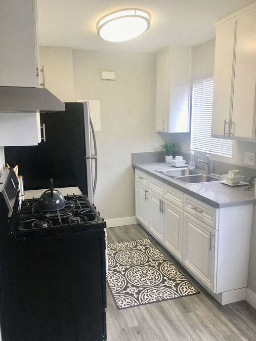 a kitchen with a stove and a sink  at The Marq Apartments LLC, Los Angeles, California
