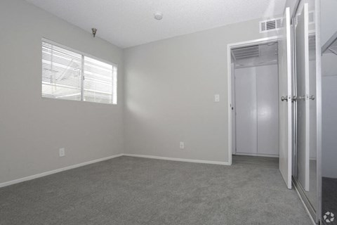 an empty bedroom with a closet and a window  at The Marq Apartments LLC, California