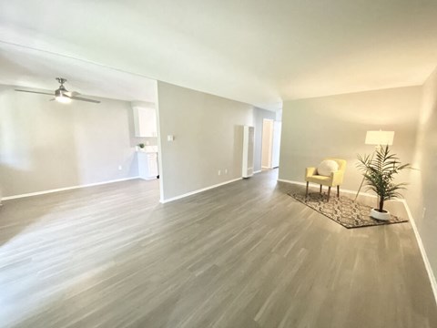 a living room with a hard wood floor and white walls