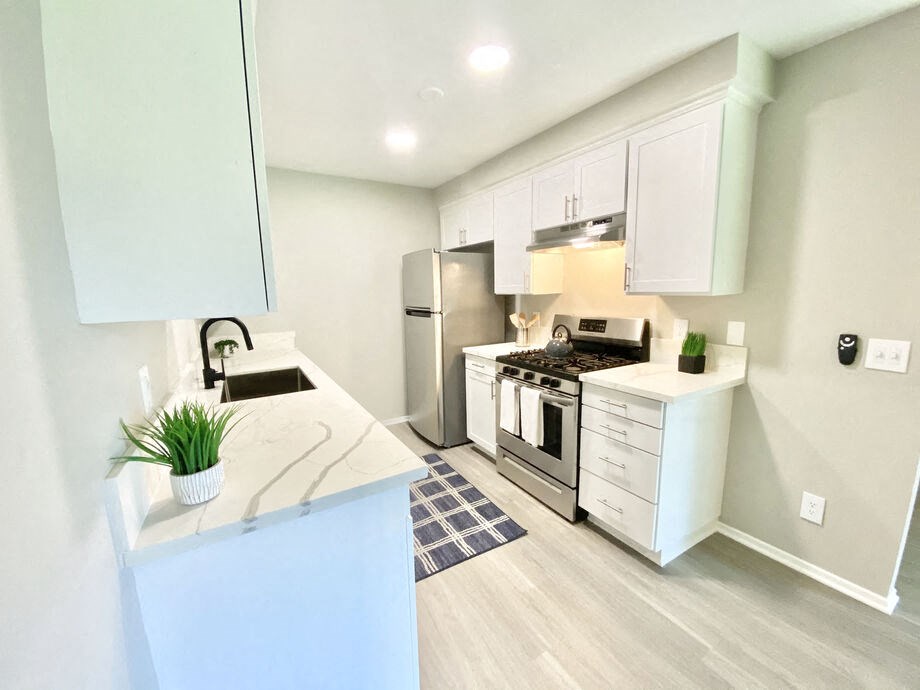 a kitchen with white cabinets and stainless steel appliances at BLVD Apartments LLC, Tarzana, 91356
