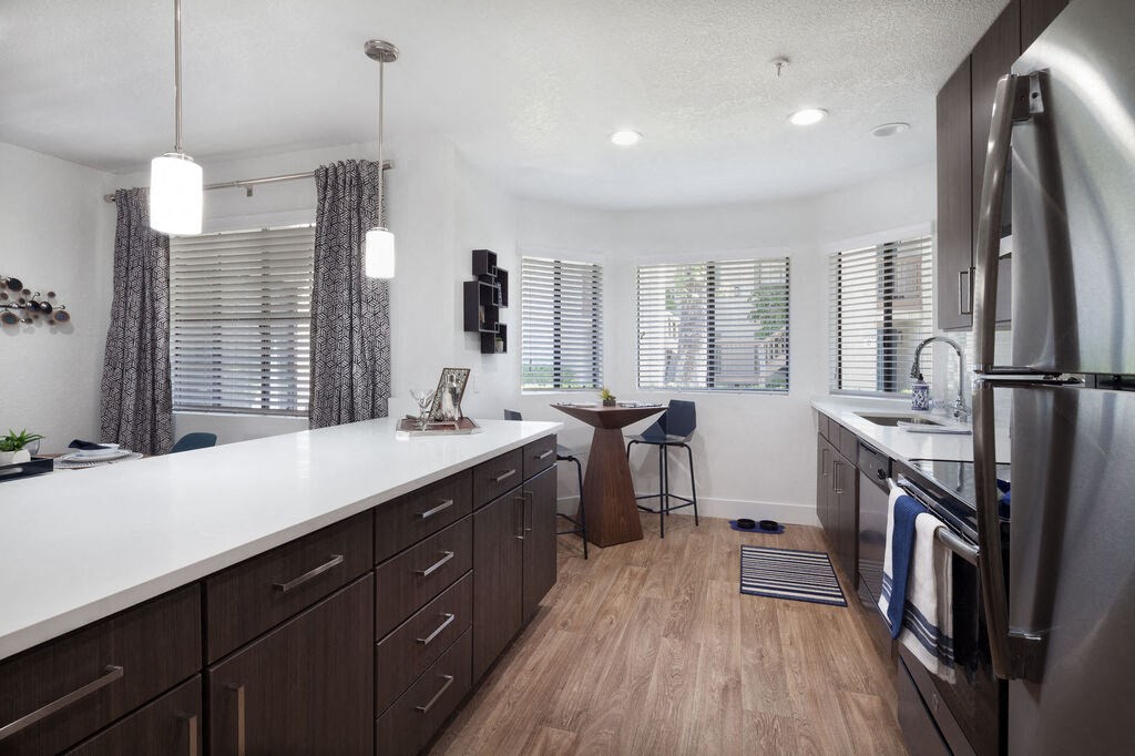 a kitchen with a sink and a refrigerator at The Bryant, Yorba Linda