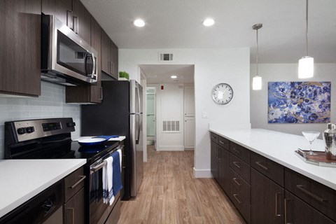 a kitchen with white counter tops and black appliances