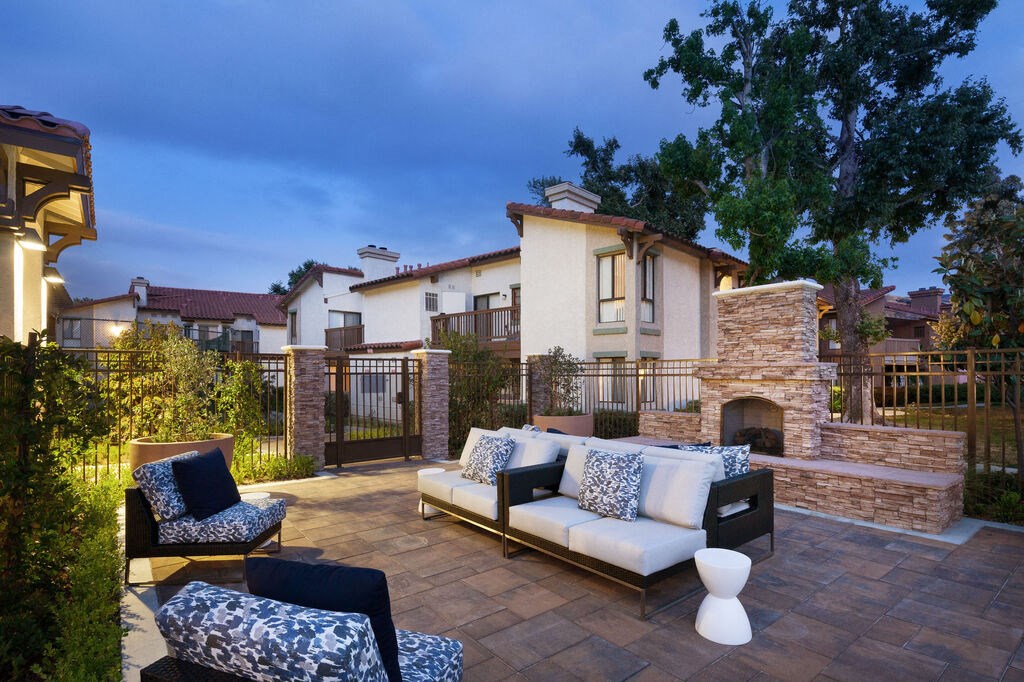 a patio with furniture and a stone fireplace at The Bryant, Yorba Linda, 92887