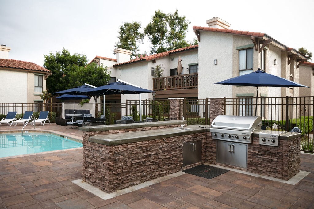 a patio with a grill and a swimming pool at The Bryant, Yorba Linda California