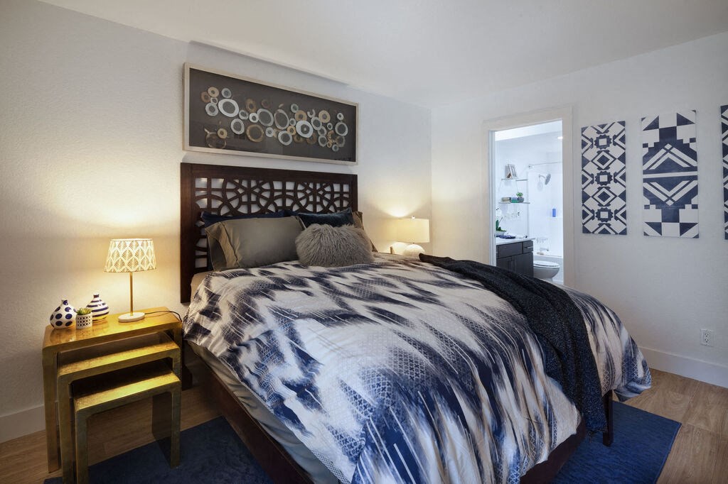 a bedroom with a bed and a nightstand with a lamp at The Bryant, Yorba Linda, 92887