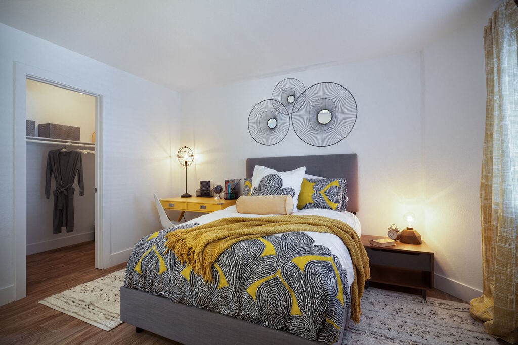 a bedroom with a bed and two mirrors on the wallat The Bryant, California, 92887