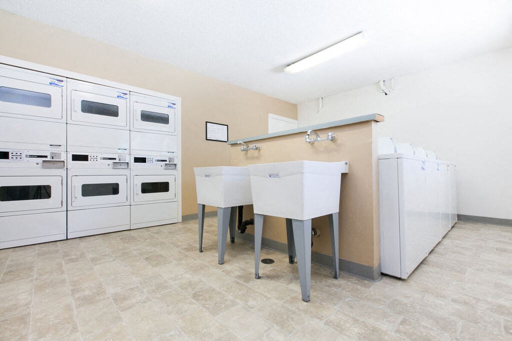 a kitchen with white appliances and a counter with two sinks at Campbell West, California