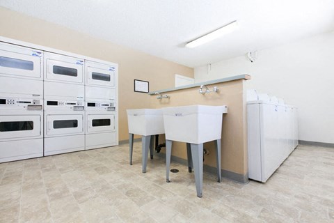 a kitchen with white appliances and a counter with two sinks