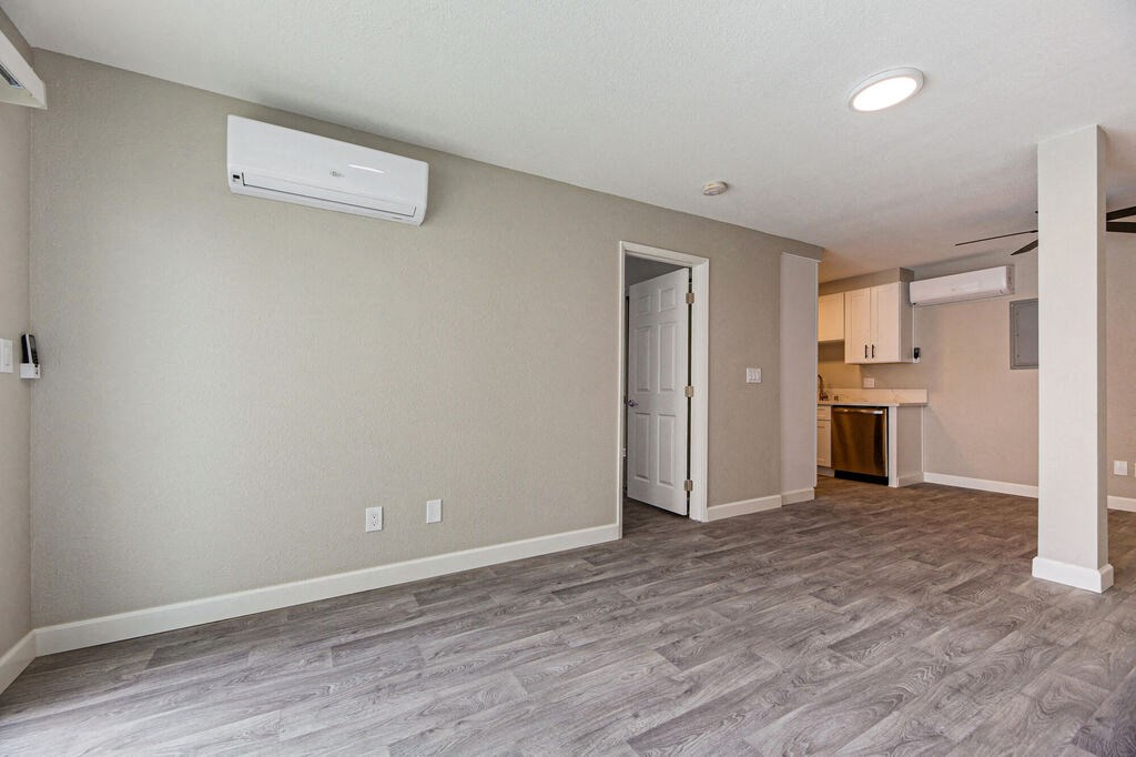 an empty living room with a door to a kitchen at Citra Apartments LLC, California